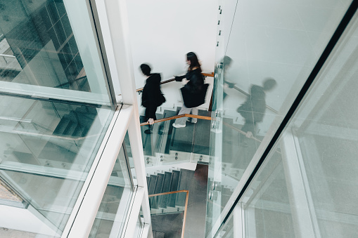 Long exposure shot of people moving down a modern staircase in the city.