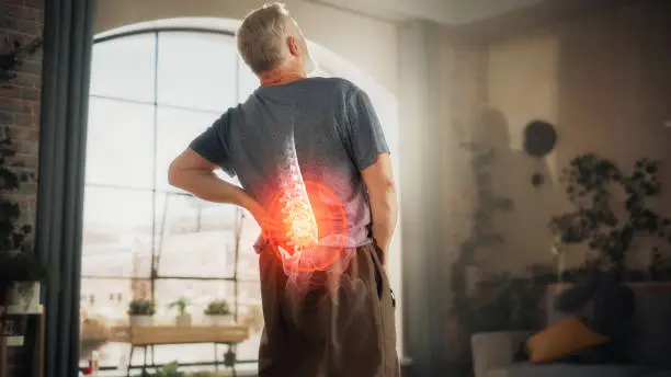 VFX Back Pain Augmented Reality Animation. Close Up of a Senior Male Experiencing Discomfort in a Result of Spine Trauma or Arthritis. Man Massaging and Stretching the Back to Ease the Injury.