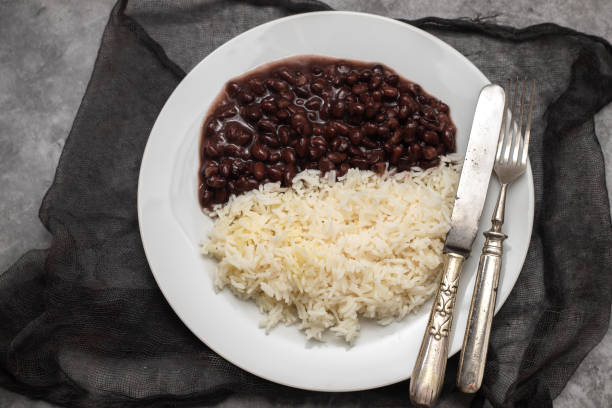 istock Black beans and boiled rice on white dish. 1458816800