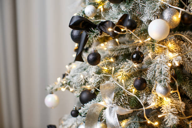istock Christmas tree close-up with white, black and silver balls, bows with garland 1458817895