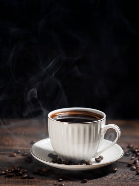 istock cup of hot coffee on a wooden table, black background 1458818018