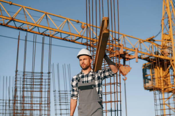 istock Against crane. With wooden plank. Man is working on the construction site at daytime 1458820536