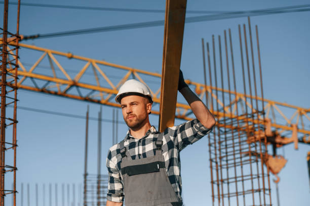istock Against crane. With wooden plank. Man is working on the construction site at daytime 1458820547