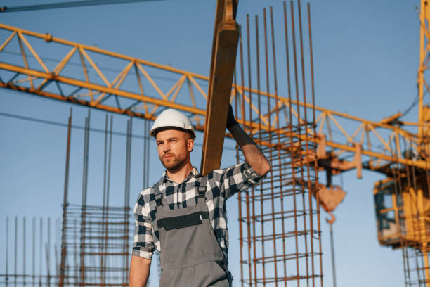 istock Against crane. With wooden plank. Man is working on the construction site at daytime 1458820557