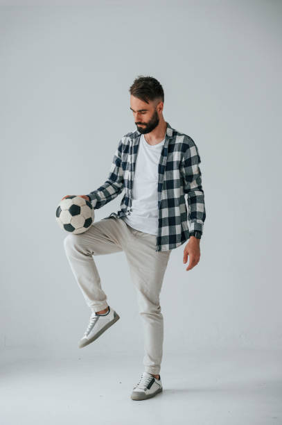 istock Playing soccer. Handsome man is in the studio against white background 1458823292