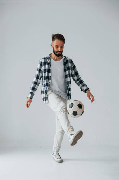 istock Playing soccer. Handsome man is in the studio against white background 1458823298