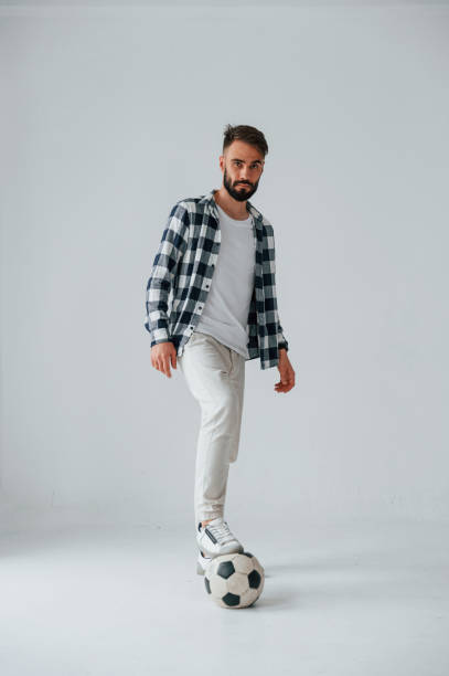 istock Playing soccer. Handsome man is in the studio against white background 1458823299