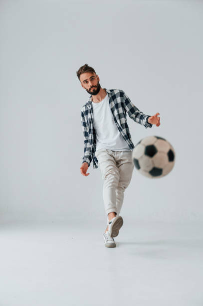 istock Playing soccer. Handsome man is in the studio against white background 1458823305
