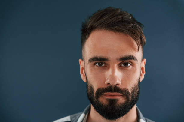 istock Close up portrait. Handsome man is in the studio against blue background 1458823343