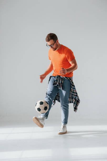istock Playing with soccer ball. Handsome man is in the studio against white background 1458826028