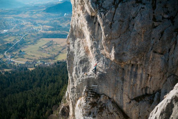 istock Woman doing rock climbing on a secure climbing route over a mountain 1458828466