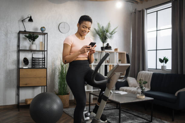 istock African female wearing sportswear writing message on her smartphone while working out 1458829522