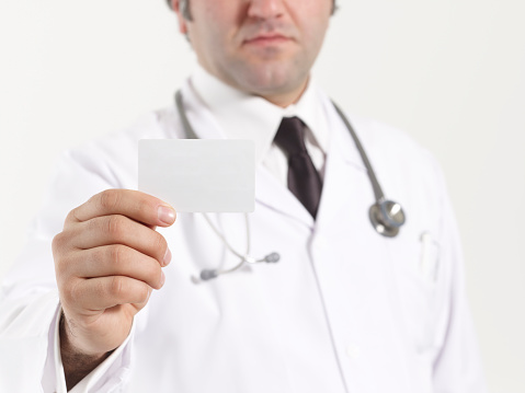 Happy smiling doctor showing business card