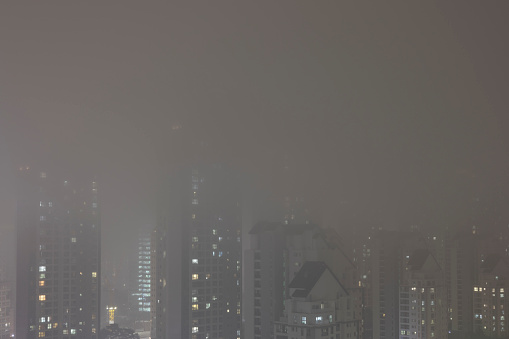 A fog-shrouded night city view, fine dust, air pollution