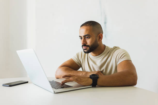istock Man with beard busy working on laptop in home office 1458834523