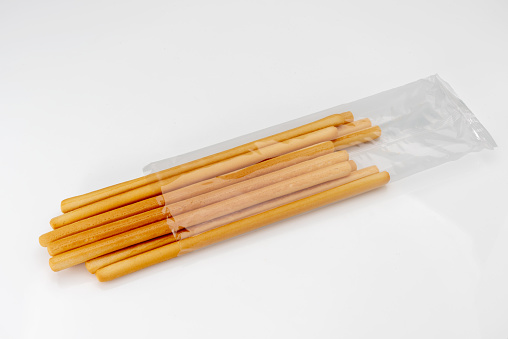 Breadsticks come out of transparent packaging. typical Italian Bread sticks isolated on whiye