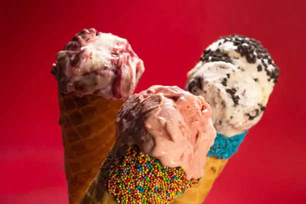 Three different flavours of Ice Cream in colourful wafer cones.