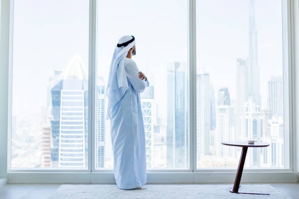 istock Side view of Arab businessman looking through window in modern office 1458836053
