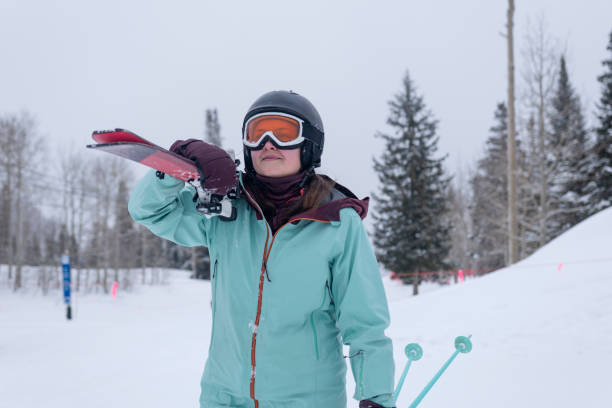 Teenage girl passing ticket gate at gondola ski lift terminal in European Alps. The girl is carrying his skis.\nCanon R5