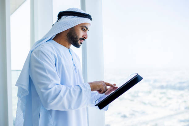 istock Side view of Arab businessman using digital tablet beside office window 1458836113