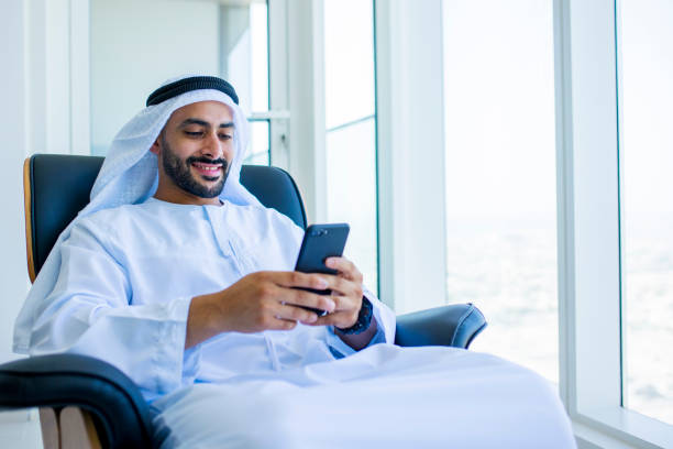istock Cheerful Arab businessman using cellphone in modern office 1458836118