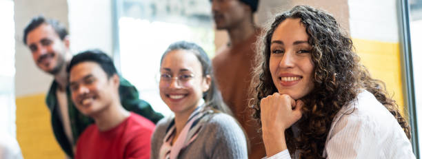 istock Horizontal banner or header with university students multiethnic team studying together on a new project in creative coworking classroom - Bright filter with focus on first woman on left 1458836294