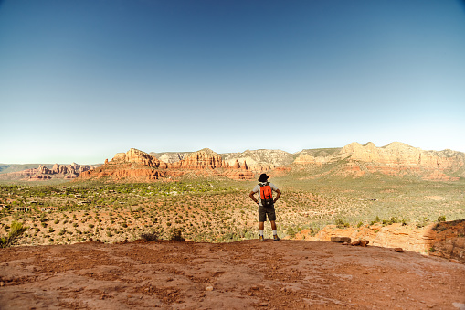 A man with a backpack in canyon in southwest America standing and enjoying the view