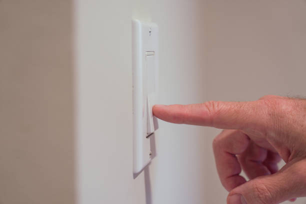 istock Closeup of male finger pushing light switch 1458836960