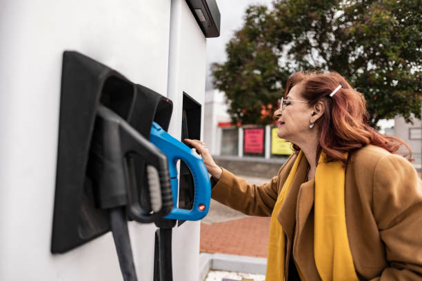 istock mature woman charging electric car 1458838650