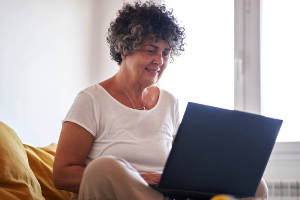 istock Mature woman using her laptop in bed 1458838729