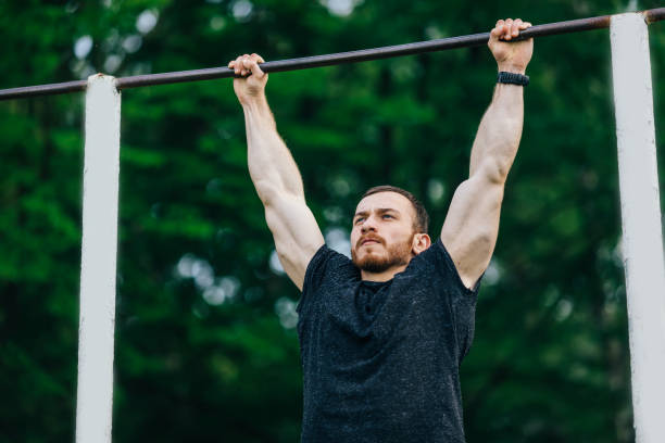 istock a young man in a black t-shirt pulls up on a horizontal bar on a 1458841637