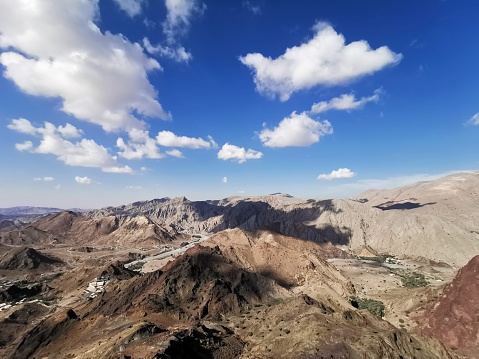 Hajar Mountains in Ras Al Khaimah in United Arab Emirates under a blue sky and white clouds