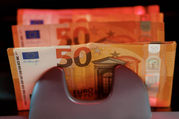 istock Banking and commercial activity, paper currency detector. Machine counter automatic calculates a large amount of 50 Euro banknotes. 1458845033