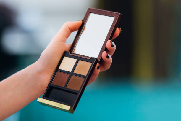 istock a woman holds a box in her hand with eye shadow and a mirror 1458845048