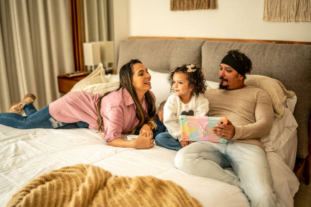 istock Parents having fun while using digital tablet with their daughter in the bedroom at home 1458845548