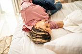Young woman having fun lying down on the bed at home