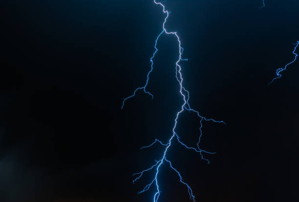 istock Electric blue lightning in stormy night sky. 1458845839