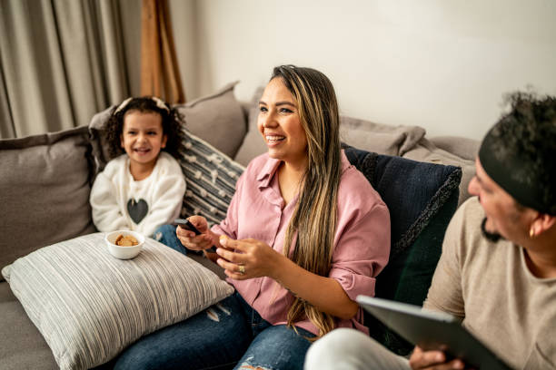 madre e hija divirtiéndose mientras ven la televisión en la sala de estar de casa - apartment television family couple fotografías e imágenes de stock