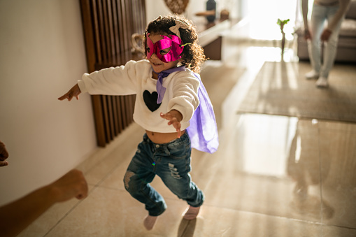 Girl toddler running in the living room at home