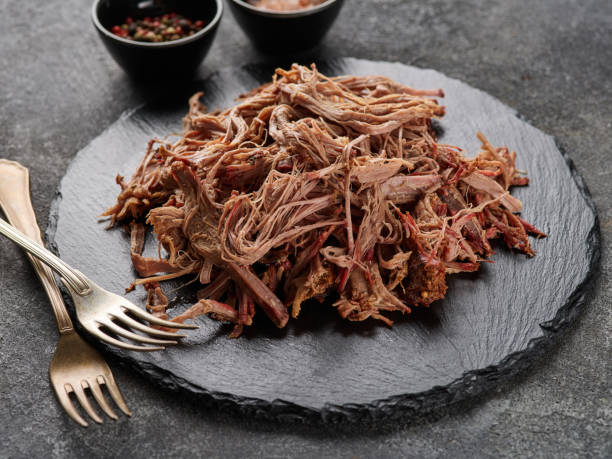 Traditional barbecue pulled pork. Slow cooked pulled pork shoulder. Juicy pork meat cooked in a smoker by low and slow