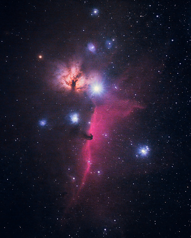 Photograph of the deep sky of the Horsehead and Flame nebulae. This photo of space and stars is taken with a telephoto lens at night.