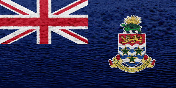 Flag of the British Cayman Islands on a textured background. Concept collage.