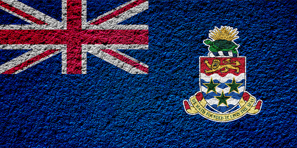 Flag of the British Cayman Islands on a textured background. Concept collage.