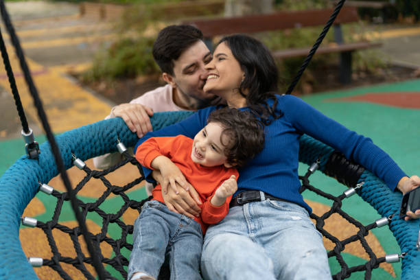 istock Family playing on the swing in the park 1458852001