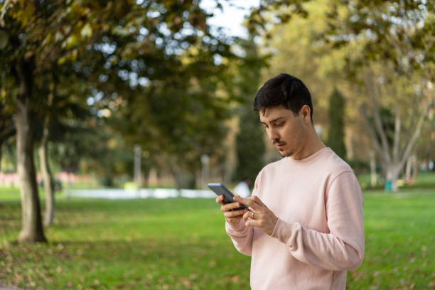 istock Man on phone in public park 1458853170