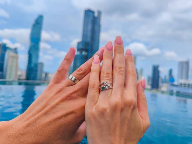 istock Hands with rings of just married couple with a Bangkok panorama in front 1458856440