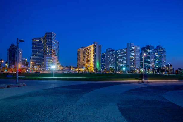 panorama of  building next to coastline in telaviv in blue hour with hotels and residential buildings - sailboat sunset tel aviv sea imagens e fotografias de stock