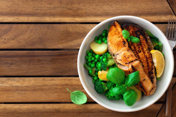 istock Dinner plate with fresh salmon steak and vegetables on wooden table with copy space top view. Diet, healthy food 1458858016