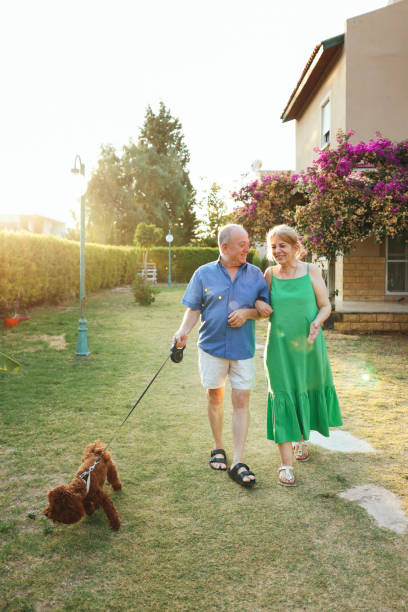 istock Senior Couple Taking Dog For Walk In Backyard 1458858342