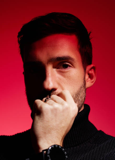 istock Face, thinking and red with a man model in studio on a color wall background for idea or contemplation. Fashion, portrait and creative with a handsome young male posing against a red background alone 1458858914